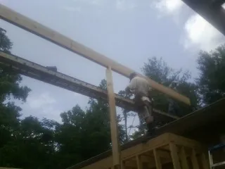Carpenter setting a ridge beam over a new addition frame — Ice Dam Removal by Roofing Brothers in Chesterfield